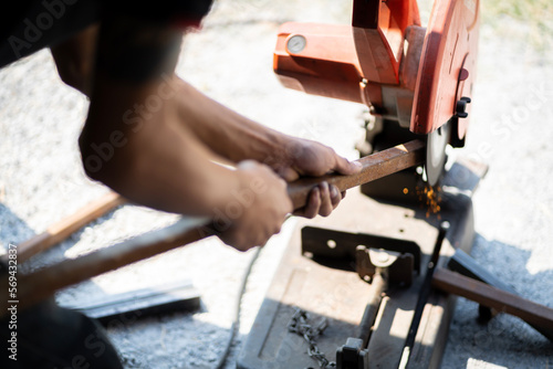 A blacksmith is using a sharpener, sparks come out while cutting.