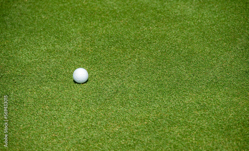 A golf ball on the green in golf course.