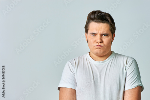 a frowning man on a gray background, copy space © Евгений Порохин