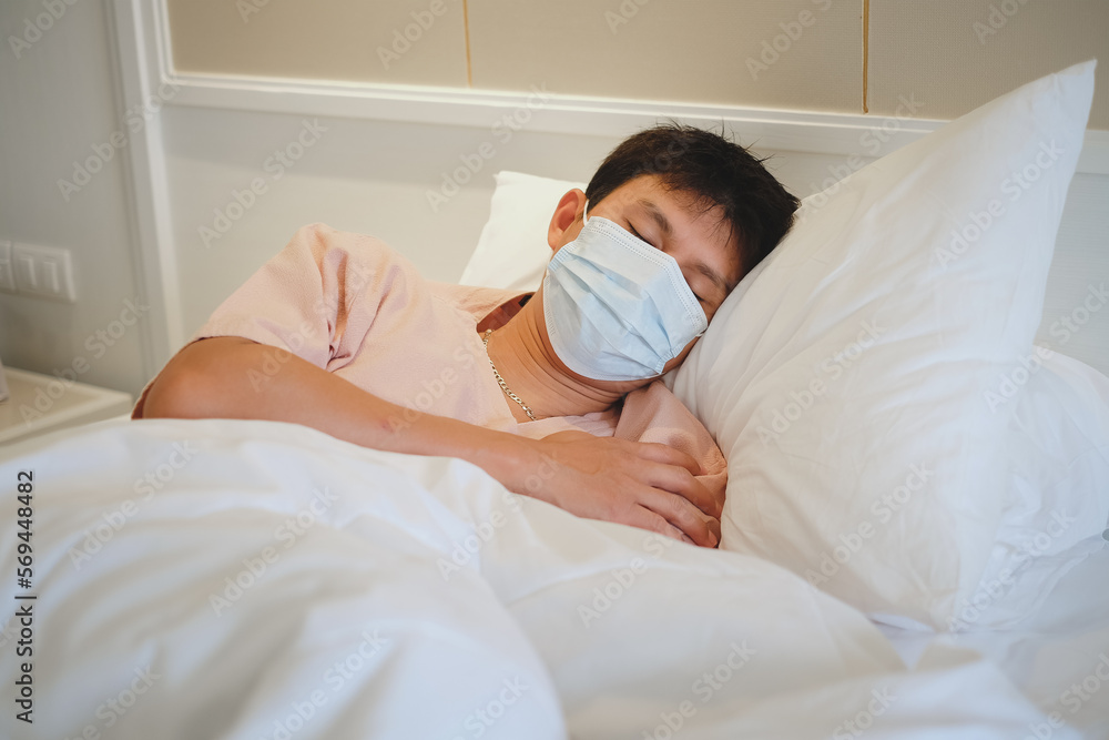 Asian male patient sleeping on bed with face mask in recovery room in hospital ward. Asian male patient sleeping on bed with face mask in recovery room in hospital ward.