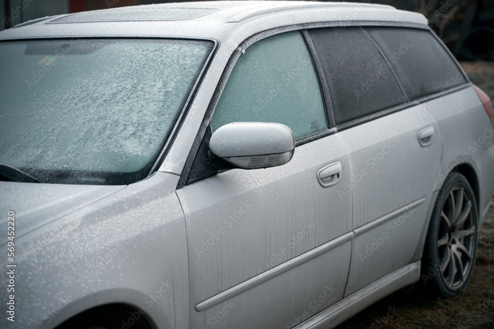 car is covered with frost. cold morning with a vehicle parked outside during night car is covered with frost. cold morning with a vehicle parked outside during night