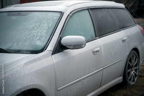 car is covered with frost. cold morning with a vehicle parked outside during night © AlexGo
