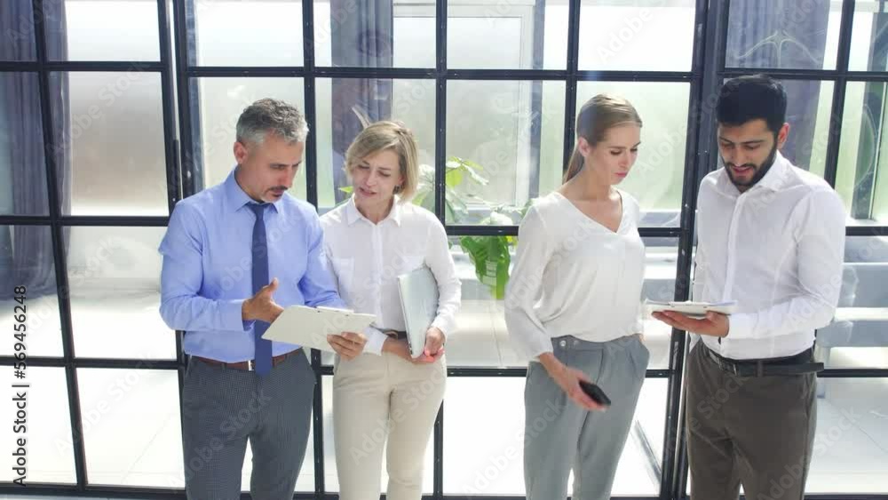 business people discussing documents standing in the office. slow motion. business people discussing documents standing in the office. slow motion.