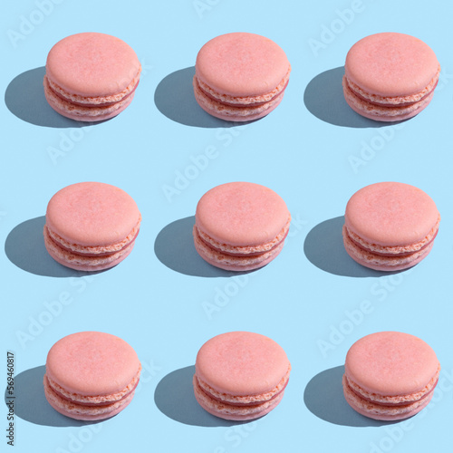 Seamless pattern with pink macaron on blue background.