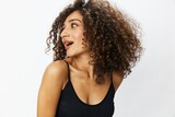 Beautiful woman with curly afro hair posing on a white isolated background smile happiness in jeans and black top emotion, hand signs, copy space