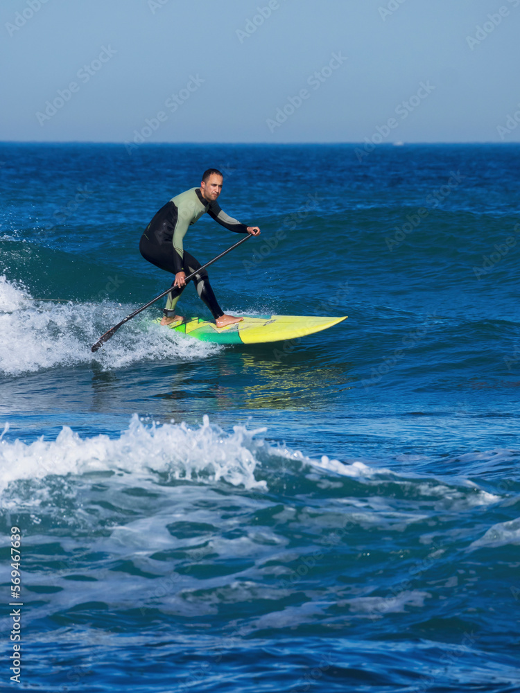 Man surfing with a stand up paddling board at sopelana beach Man surfing with a stand up paddling board at sopelana beach