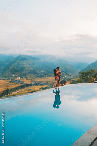 Young couple traveler relaxing at infinity pool with beautiful nature landscape  mountains in Sapa, Vietnam © Nichapa