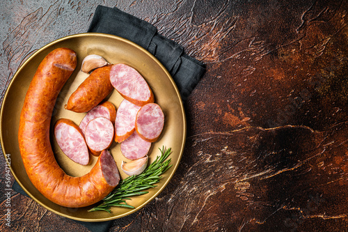 Polish Smoked sausage in a steel plate. Dark background. Top view. Copy space