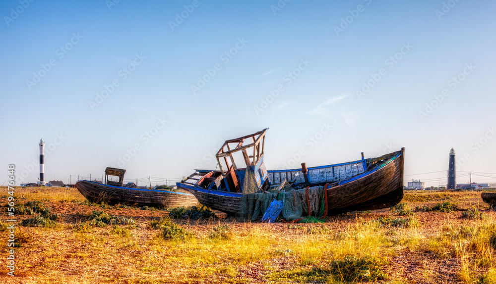 Abandoned Boat Wrecks on the Beach at the Dungeness Headland, Kent, England, with the Old and the New Lighthouse