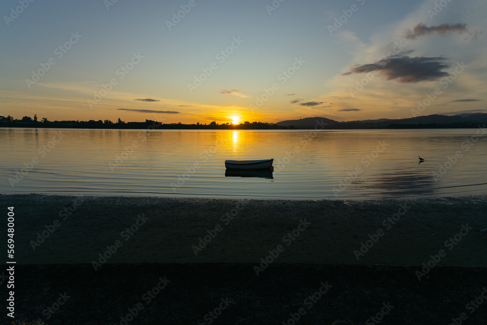 Sunrise over bay and small dinghy