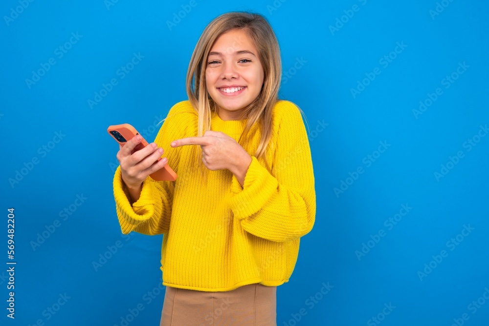 Portrait cute astonished caucasian teen girl wearing yellow sweater over blue studio background impressed unbelievable unexpected incredible notification advice Portrait cute astonished caucasian teen girl wearing yellow sweater over blue studio background impressed unbelievable unexpected incredible notification advice