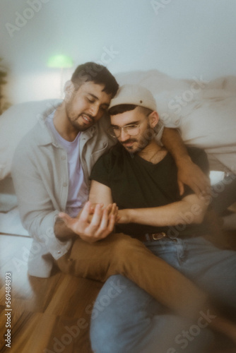 Gay couple spending leisure time sitting at home photo