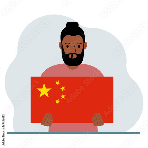 A man holds a Chinese flag. The concept of demonstration, national holiday or patriotism. Nationality.