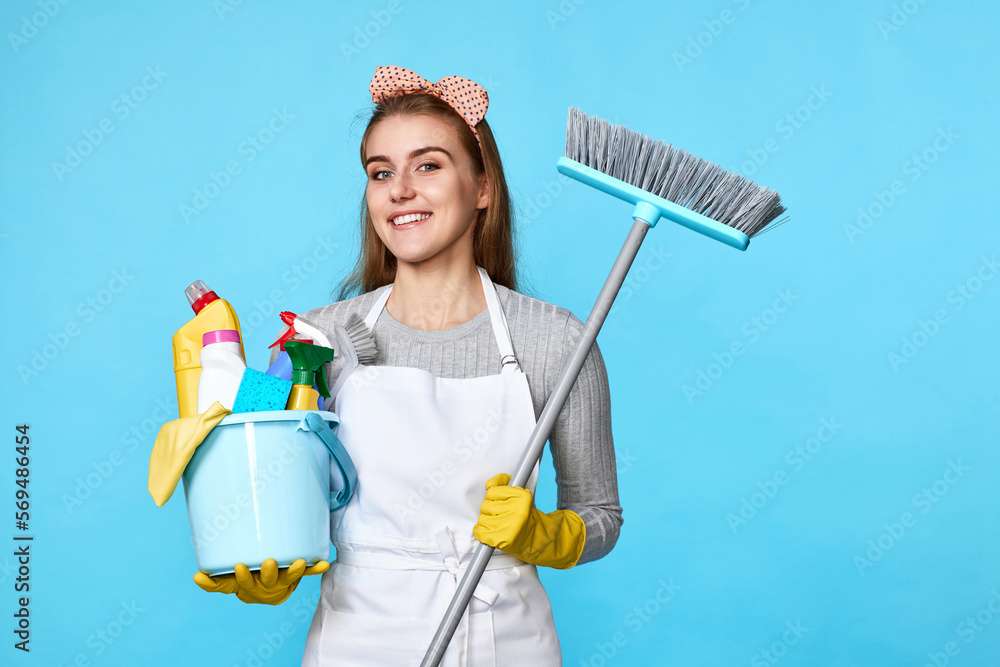 woman in gloves holding bucket of detergents and broom woman in gloves holding bucket of detergents and broom