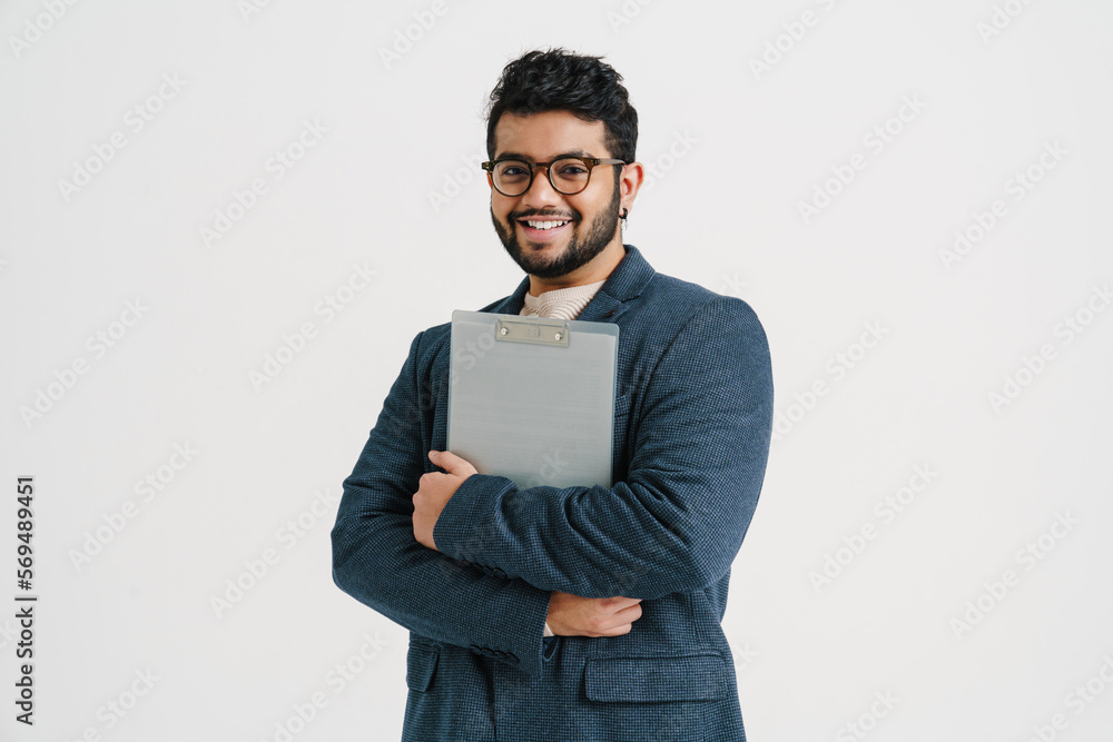 Young indian man holding clipboard isolated over white wall Young indian man holding clipboard isolated over white wall