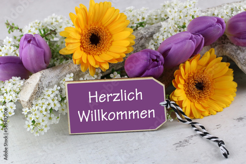 Blumenarrangement mit dem Text Herzlich Willkommen. photo