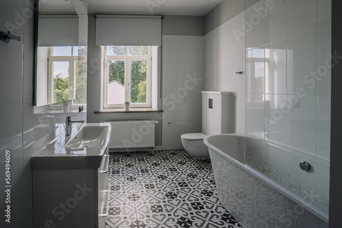 Photo Interior of white bathroom with bathtub and toiletries