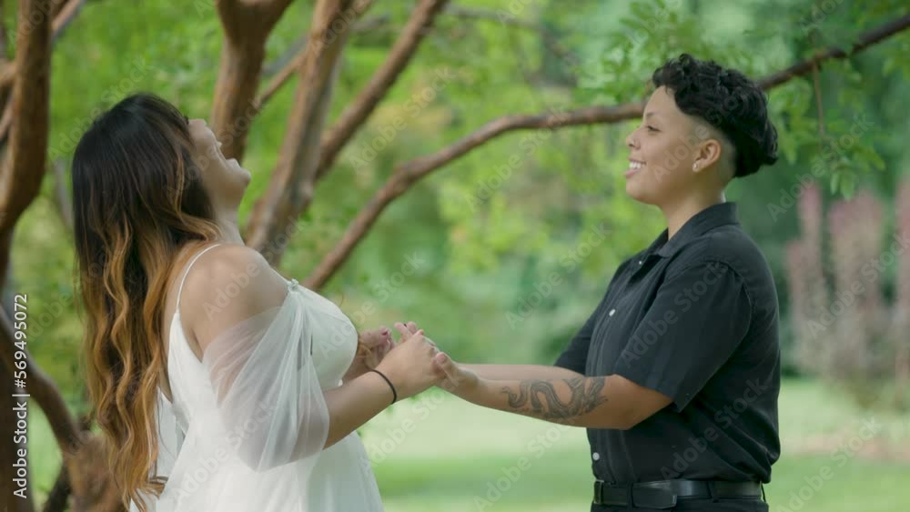 Same-Sex Couple Wedding Day. Happy joyful beautiful and in love lesbian couple holding hands, smiling and laughing. Marriage equality LGBTQ+ Shot in Slow Motion 4K. Same-Sex Couple Wedding Day. Happy joyful beautiful and in love lesbian couple holding hands, smiling and laughing. Marriage equality LGBTQ+ Shot in Slow Motion 4K.