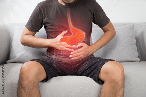 Acid reflux or Heartburn, The photo of stomach is on the men's body against gray Background, Bad health, Male anatomy concept photo