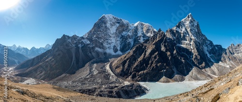 Landscape shot of beautiful Cholatse mountains next to a body of water in Khumbu, Nepal photo