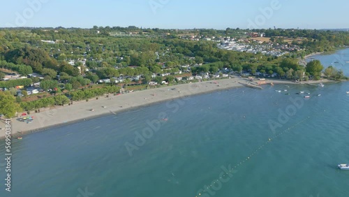 Wallpaper Mural Boats and swimmers play in the Ocean next to a massive campsite on the beach. Lake Garda, Italy.  Torontodigital.ca