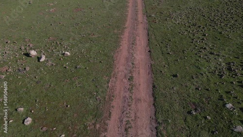 Drone shot following dirt road with tire tracks running up rocky slope, Israel photo