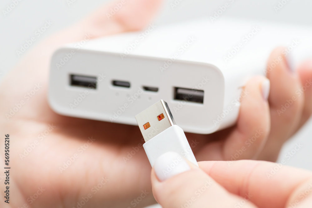 Inserting usb type-a cable to big modern powerbank. Charging electronic devices with powerbank