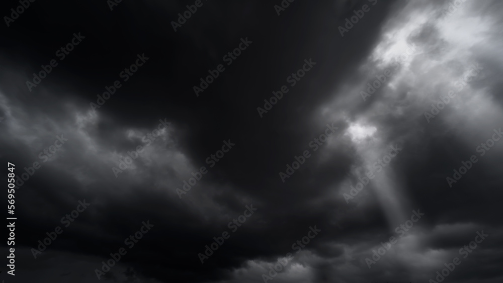 Obraz premium dark dramatic sky with black stormy clouds before rain or snow as abstract background, extreme weather, the sun shines through the clouds, high contrast photo