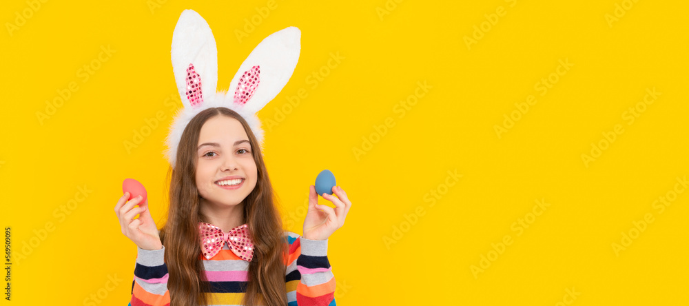 smiling teen child in bunny ears and bow tie hold easter eggs on yellow background. Easter child horizontal poster. Web banner header of bunny kid, copy space. smiling teen child in bunny ears and bow tie hold easter eggs on yellow background. Easter child horizontal poster. Web banner header of bunny kid, copy space.