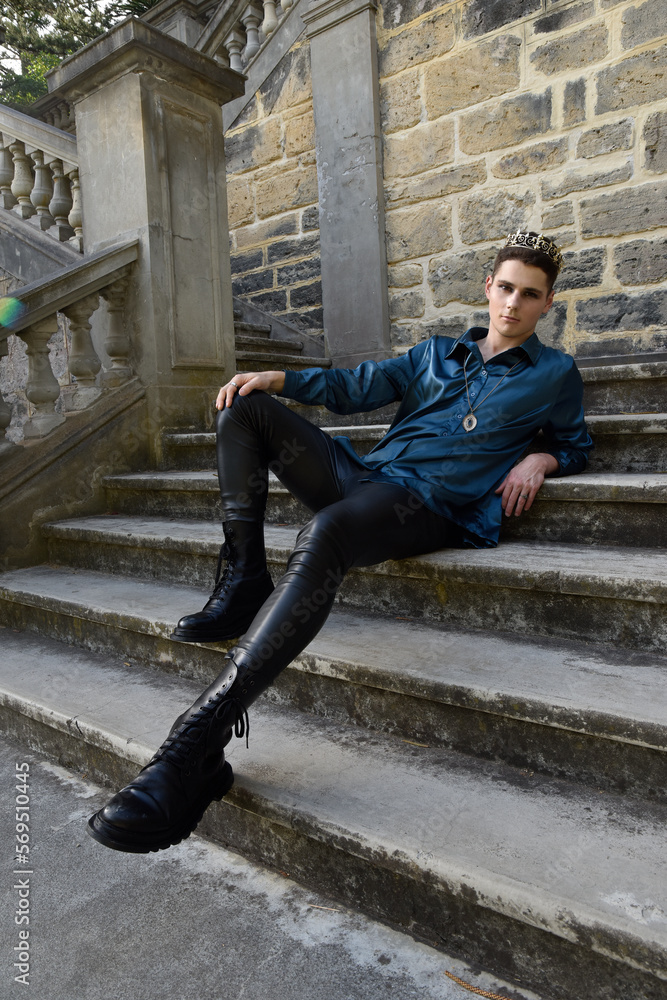 portrait of handsome brunette male model wearing fantasy medieval prince costume, romantic silk shirt. Wandering around historical castle location background with stone staircase. portrait of handsome brunette male model wearing fantasy medieval prince costume, romantic silk shirt. Wandering around historical castle location background with stone staircase.
