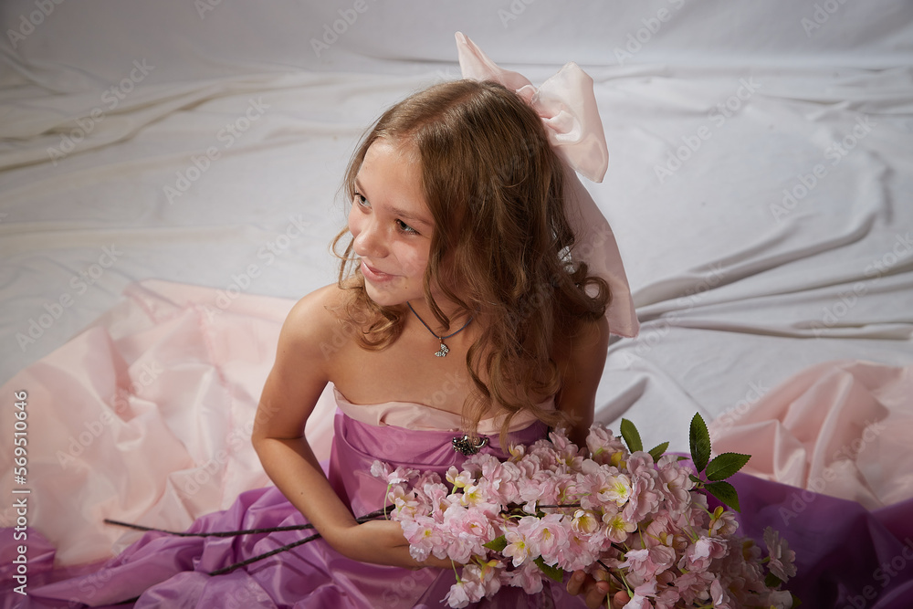 Portrait of cute kid girl posing in pink beautiful dress on a white background. Model in studio looking as gentle magic princess from fairy taly having photo shoot on white background Portrait of cute kid girl posing in pink beautiful dress on a white background. Model in studio looking as gentle magic princess from fairy taly having photo shoot on white background