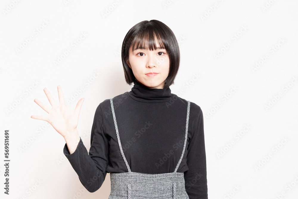 手で数字の5を示す女性