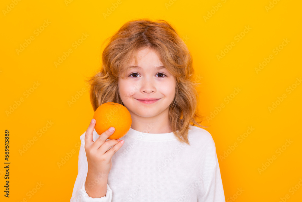 Kid with orange in studio. Studio portrait of cute child hold orange isolated on yellow background. Kid with orange in studio. Studio portrait of cute child hold orange isolated on yellow background.