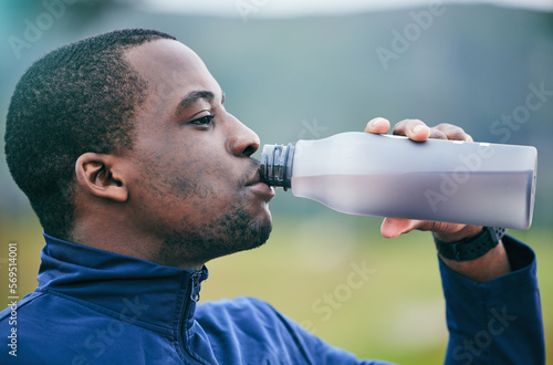 Fitness, health and side profile of black man drinking water to hydrate after running, exercise and workout. Healthy, sports and African athlete with a drink after training and cardio in Germany