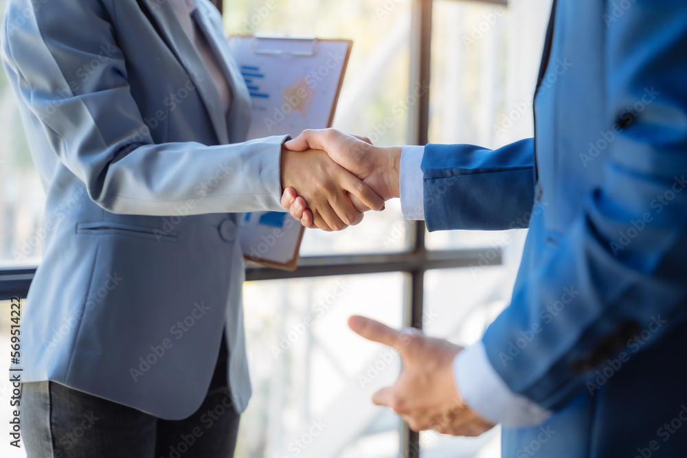 Business men and women shake hands confidently professional investor working with new startup project at an office meeting.
