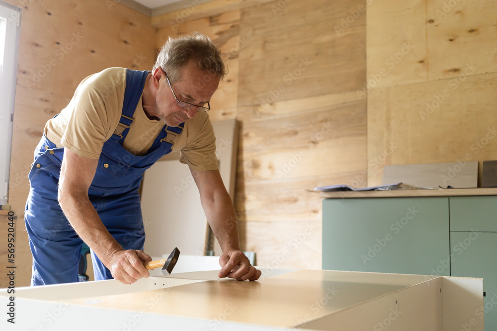 mature adult elderly senior man building wooden house, assembling furniture according to the instruction using different tool, drill, screwdriver. active old age, male hobby retirement. vertical mature adult elderly senior man building wooden house, assembling furniture according to the instruction using different tool, drill, screwdriver. active old age, male hobby retirement. vertical