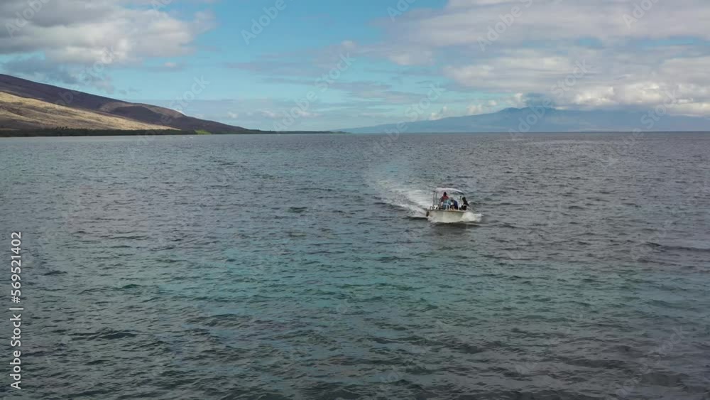 Drone tracking flat bottom white boat moving on the open ocean, Molokai Drone tracking flat bottom white boat moving on the open ocean, Molokai