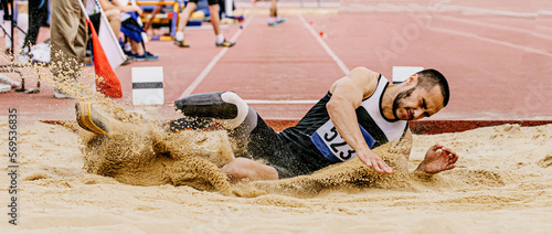Canvas Print disabled athlete landing in sand on athletics competition