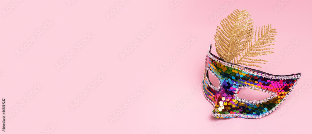 Festive face mask for carnival or masquerade celebration on colored background. Banner with copy space