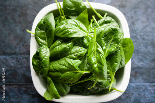 Fresh spinach leaves in a bowl, green vegetables, rustic style, healthy lifestyle, proper nutrition. Top view