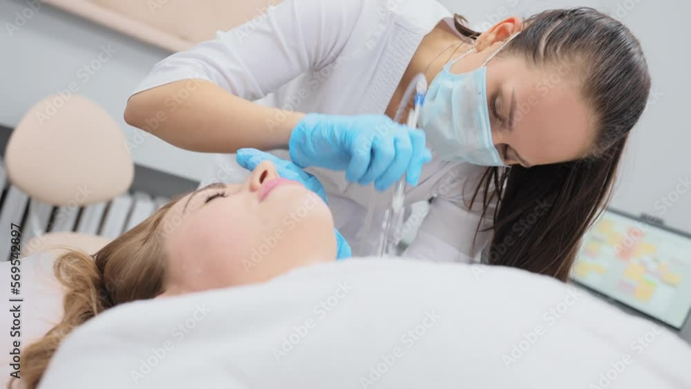 cosmetologist performs a gas-liquid peeling procedure - rejuvenation and regeneration of the skin using a jet consisting of oxygen and liquid. cosmetologist performs a gas-liquid peeling procedure - rejuvenation and regeneration of the skin using a jet consisting of oxygen and liquid.