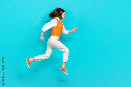 Full body photo of successful school girl student running jump hurry get more useful knowledge empty space isolated on aquamarine color background