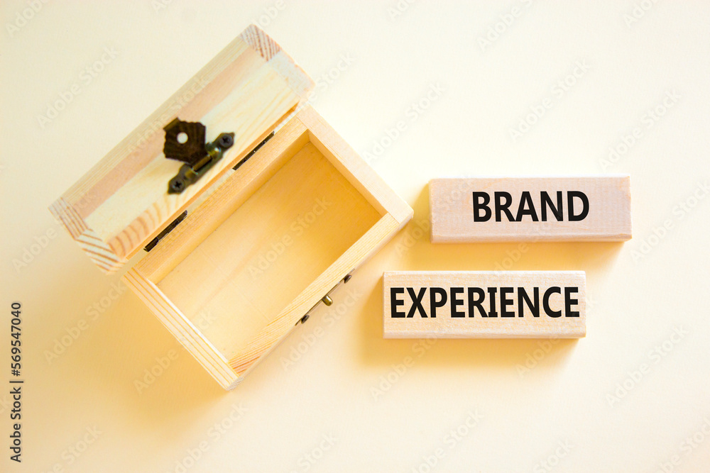 Brand experience symbol. Concept words Brand experience on wooden blocks. Beautiful white table white background. Wooden empthy chest. Business branding and brand experience concept. Copy space.