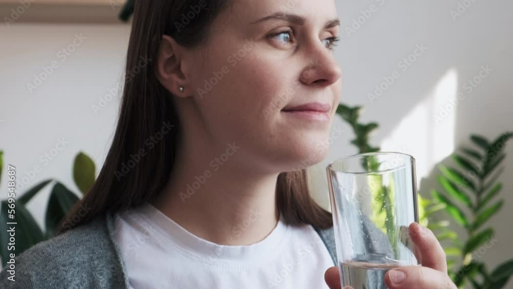 Happy beautiful peaceful young pregnant woman drinking glass of fresh pure mineral water sitting on sofa at home, preventing dehydration enjoying daily healthcare habit. Healthy pregnancy concept Happy beautiful peaceful young pregnant woman drinking glass of fresh pure mineral water sitting on sofa at home, preventing dehydration enjoying daily healthcare habit. Healthy pregnancy concept
