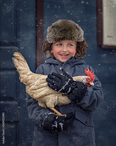 boy in a fur hat holding a chicken