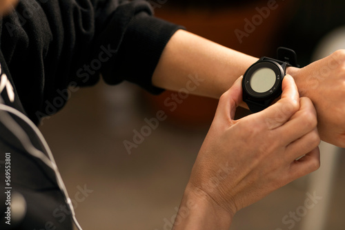 Caucasian millennial female athlete in sportswear checks pulse on fitness tracker with empty space, cropped