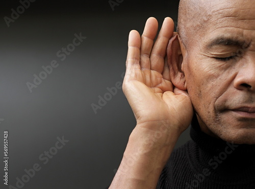 deaf man suffering from deafness and hearing loss on grey background with people stock image stock photo