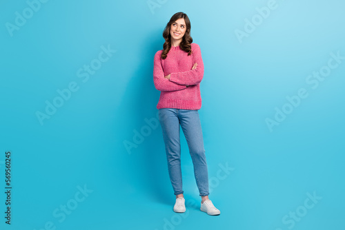 Full length photo of young lovely girlish woman crossed hands wear trendy casual outfit looking empty space promo isolated on blue color background