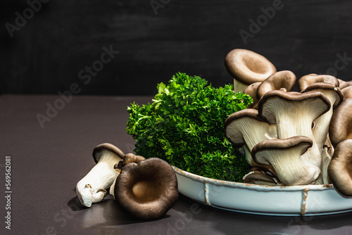 Delicious organic oyster mushrooms with fresh parsley. Source of beta glucan, black stone background photo