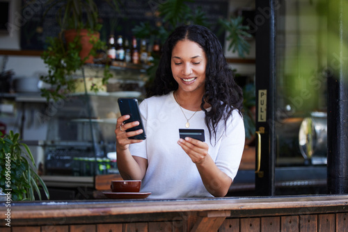 Woman, phone and credit card with smile for ecommerce, online shopping or purchase at coffee shop. Happy female customer on smartphone for internet banking, app or wireless transaction at cafe photo